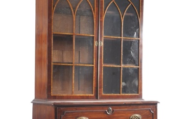 A 19th century George III flame mahogany secretaire bookcase having an inlaid glazed top with shaped gallery front over double astragal glazed doors revealing a shelving interior. The base a top faux drop down drawer opening to reveal a fully...
