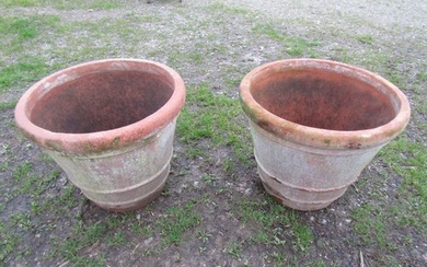 A pair of large weathered terracotta planters of circular ta...