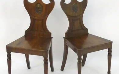 A pair of mahogany Regency hall chairs with shaped and