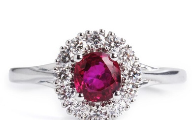 A ruby and diamond ring set with a cushion-cut natural Burma ruby weighing app. 0.71 ct. encircled by numerous brilliant-cut diamonds weighing a total of app. 0.32 ct., mounted in 18k white gold. Colour: River (D). Clarity: VVS. Size app. 53.5.