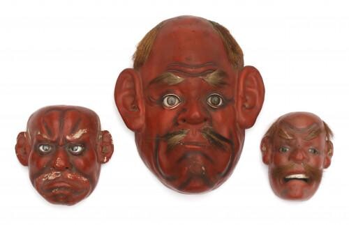 A set of three red lacquer Japanese Noh masks with glass eyes and facial hair. Meiji period (1886-1912).