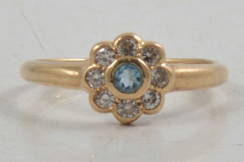A synthetic stone and cubic zirconia daisy cluster ring.