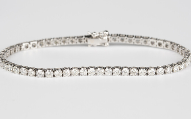 A white gold and diamond bracelet, claw set with a row of circular cut diamonds, on a snap clasp, de