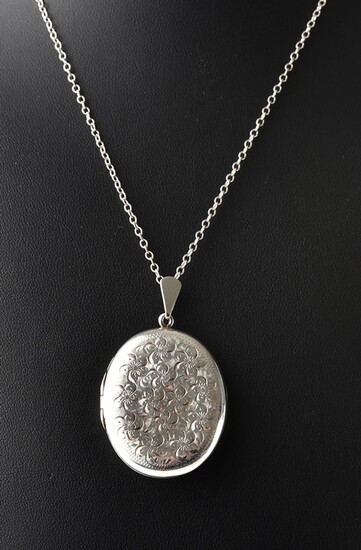 AN ENGLISH OVAL LOCKET WITH ENGRAVED FLORAL DECORATION IN STERLING SILVER, WITH CHAIN