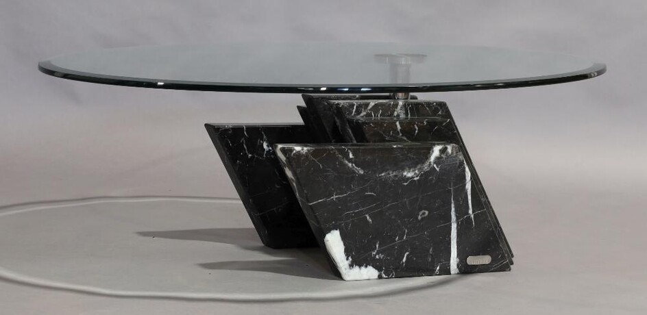 An Artedi coffee table, circular glass top raised on black marble base, 33cm high, 102cm diameter
