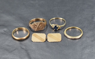 An assortment of gold rings comprising a sapphire solitaire with pierced heart motifs to the