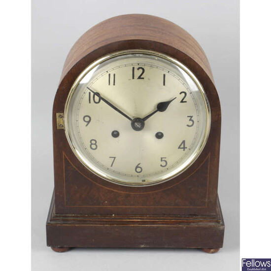 An early 20th century inlaid mahogany cased arch topped mantel clock.