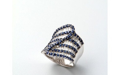 An important corset ring in white gold made of a tormented alternation of baguette diamonds and sapphires.