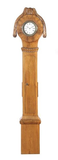 Biedermeier clock case, 2nd quarter 19th century, walnut, pillar-like base with a carved leaf wreath, the attached clock case in round form is crowned with a leaf ornament and two carved leaf garlands hanging down at the sides, h: 222 cm. Baseboard...