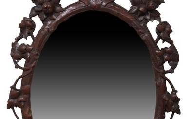 Black Forest Carved Walnut Oval Overmantel Mirror, late 19th c., the pierced frame with a lion's