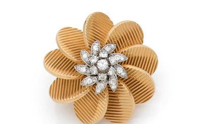 Broche clip en or 18k (750‰) et platine stylisant une fleur, les pétales à décor...