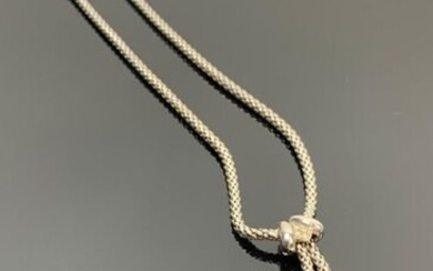 Collier négligé en or blanc, orné en pendant d'une perle grise et d'une perle blanche.