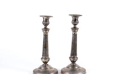 Coppia di candelieri in argento con fusto a colonna scanalata e bordure baccellate. Milano, secolo XIX (g 490) (h. cm…