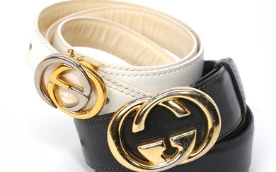 Gucci A set comprising two belts of respectively white and black leather...