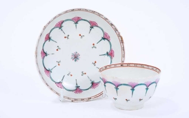 Lowestoft tea bowl and saucer, enamelled with a wheel-like design in green and pink, within a red and black ermine border, 11.9cm diameter