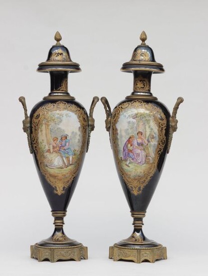Pair of porcelain VASES covered in baluster shape with polychrome enamel decoration, in reserves framed with gilding on a navy blue background, gallant scenes and landscapes, feet, handles and lids in chased and gilded bronze, work of the 19th century...