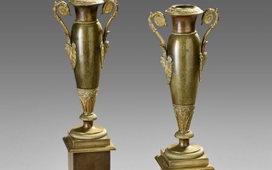 Paire de vases fuseaux en bronze patiné. Ils sont ornés de deux anses enroulées et...