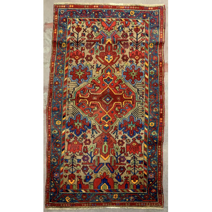 Tappeto Bachtiari, Persia, secolo XX. Decoro con medaglione rosso su fondo cammello (cm 190x104) (lievi difetti)
