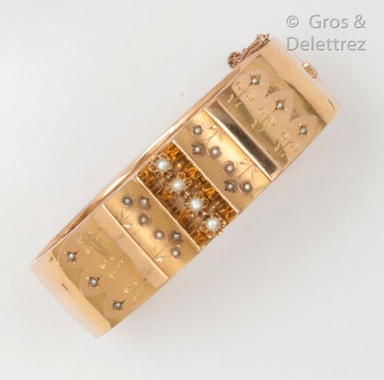 Yellow gold "Opening rush" bracelet, decorated with a central motif of arabesques set with pearls. Inside length: 16.5cm. Gross weight: 25.6g.