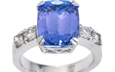 A TANZANITE AND DIAMOND RING The cushion cut tanzanite weighing 6.0cts flanked by round brilliant cut diamonds to each shoulder tota...