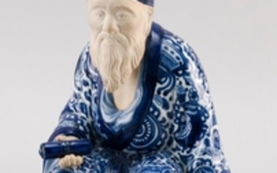 BLUE AND WHITE KUTANI PORCELAIN FIGURE In the form of Jurojin seated and holding a scroll. Kutani mark on base. Height 11.5".