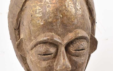 A Baule, Ivory Coast, brass clad mask presented on contemporary...