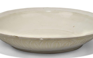 A Chinese Dehua porcelain dish, Yuan dynasty, moulded with band of stiff vertical lotus leaves to the exterior, 21cm diameter