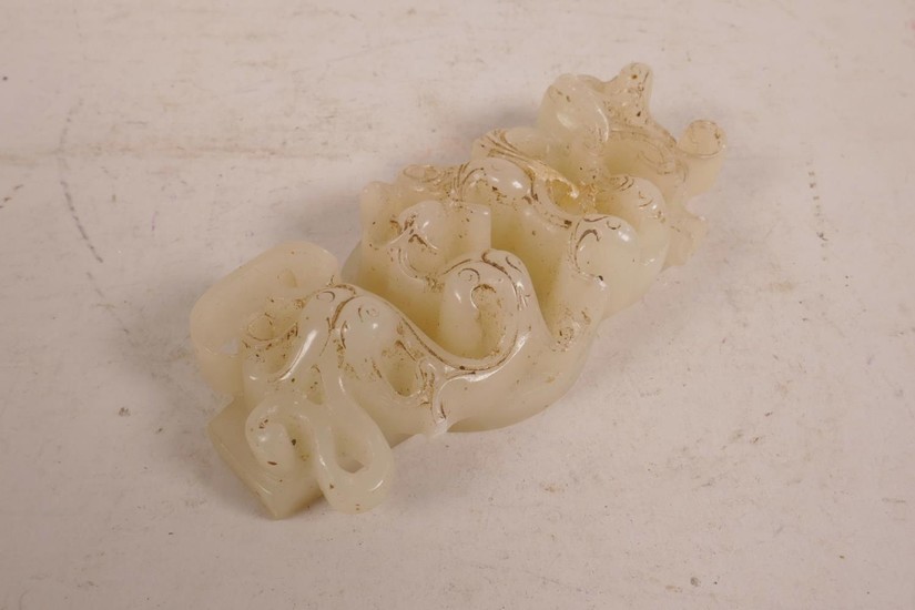 A Chinese carved white jade pendant decorated with entwined ...