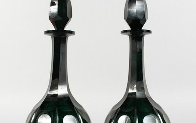 A GOOD PAIR OF GREEN CUT GLASS DECANTERS AND STOPPERS.