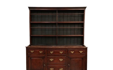 A George III oak cupboard dresser and Delft rack, the base w...