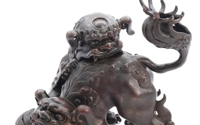 A Japanese patinated bronze center in shape of two Shishi at play. Signed Daiho. Meiji 1868–1912. H. 14 cm.