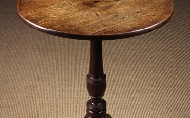 A Small Oak Tilt-top Tripod Table. The round planked top on a turned urn-knopped centre column and o