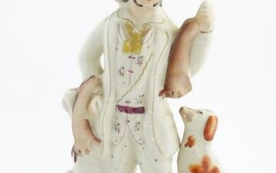 A Staffordshire pottery huntsman with a seated dog, and