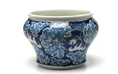 A blue and white porcelain spittoon painted with dragons writhing amidst clouds on a blue ground