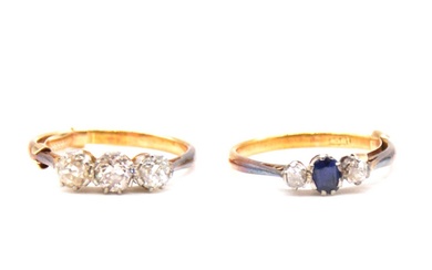 A diamond three stone ring and a sapphire and diamond three stone ring.
