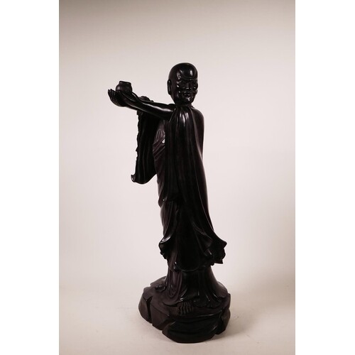 A large Chinese carved hardwood figure of Lohan holding a ce...