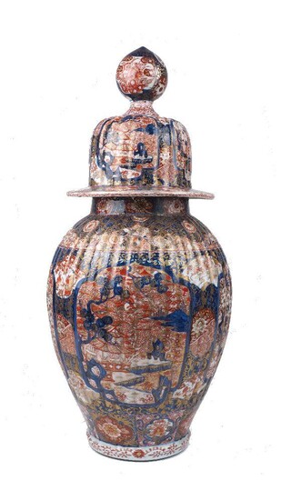 A large Japanese Imari jar and cover, late 19th century, of baluster form, decorated with panels of blossoming flowers and garden views, with red painted nine character marks to base, 74cm high