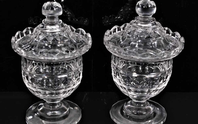 A pair of 19th century cut glass sweet meats/bonbonnieres and covers, with wavy rims, diamond, facet-cut and other patterns, on circular bases, 16.5cm high