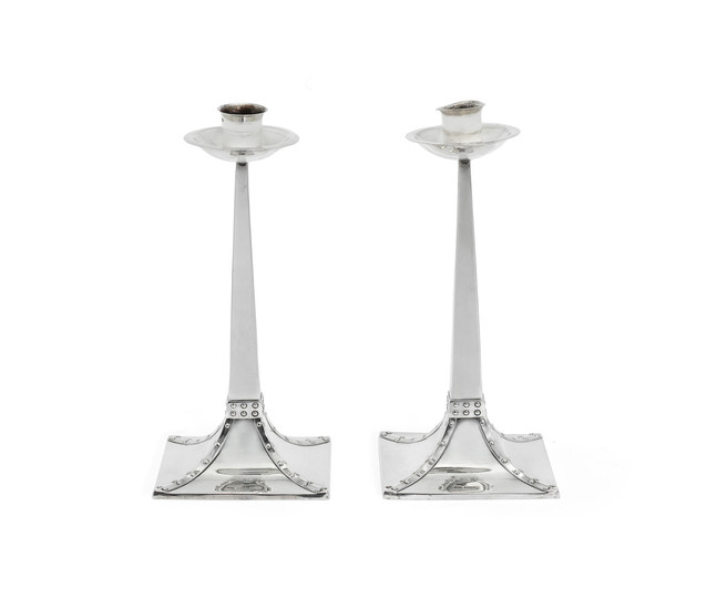 A pair of Edwardian Arts and Crafts silver candlesticks