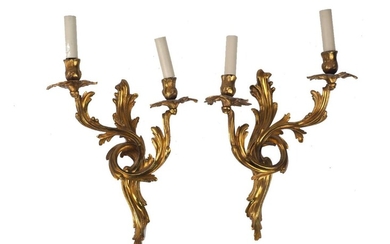 A pair of French Rococo-style gilt metal two light wall appliques, 20th century, with scrolling foliate design, 40cm high, 31cm wide