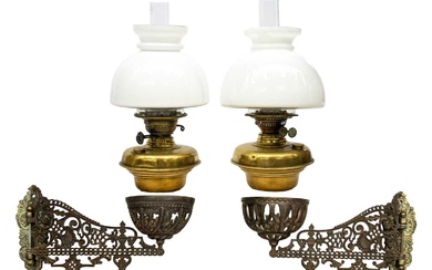 A pair of late Victorian Aesthetic movement cast iron and brass oil wall lights.
