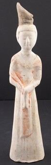 A pottery figure of a lady with red pigments to...