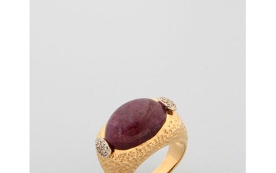 A yellow gold ring with a cabochon ruby in the centre, enhanced by two small diamond motifs.x000D_