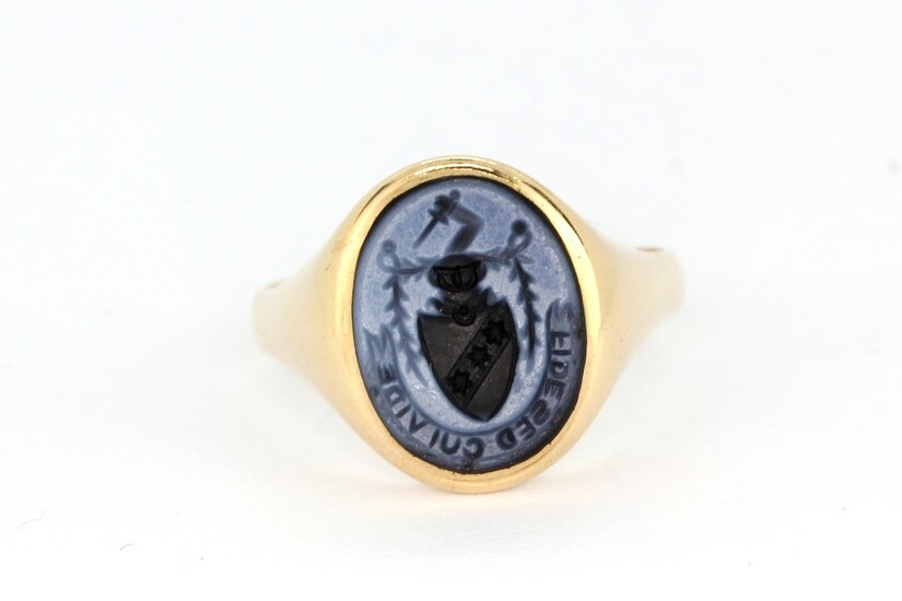 A yellow metal (tested 9ct gold) signet ring set with carved onyx, (O.5).