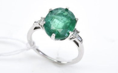 AN EMERALD AND DIAMOND RING-The oval cut emerald weighing 4.89ct, shouldered by diamonds totalling 0.15cts, in platinum, ring size N.