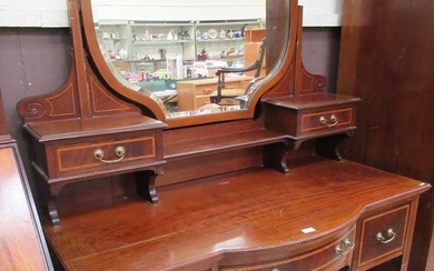 An Edwardian Sheraton revival serpentine fronted dressing table having swing...