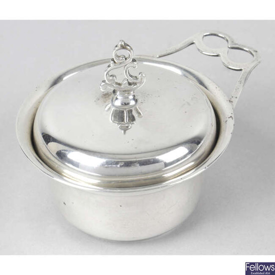An Edwardian silver lidded pot with single handle, inset with a George II coin.