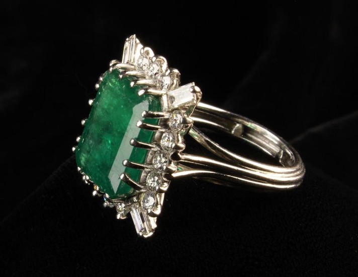An Emerald and Diamond White Gold Ring. The central emerald cut stone surrounded by 1.7 carat of dia