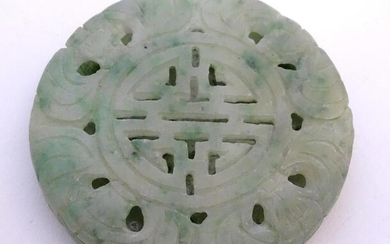An Oriental jade roundel carving depicting a stylised