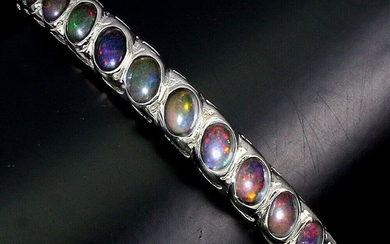 An opal bracelet set with numerous opal cabochons, mounted in rhodium plated sterling silver. Diam. 5.5 cm.